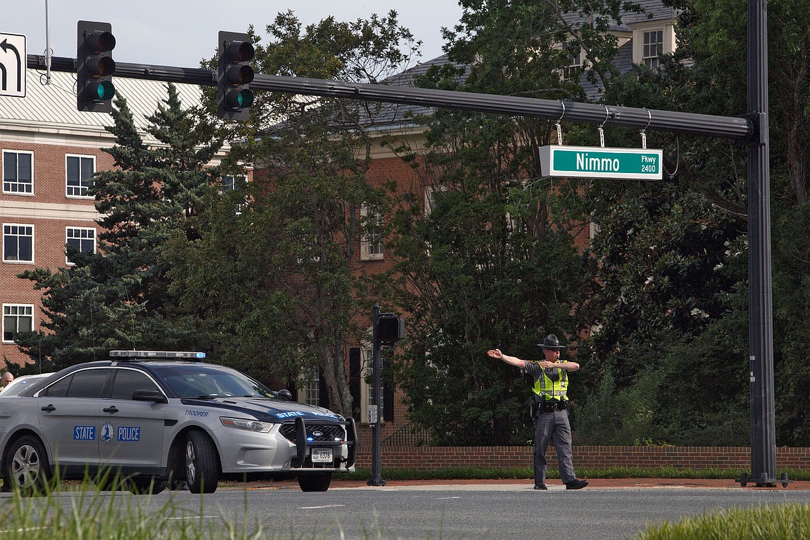 A police officer directs traffic away from the intersection of Princess Anne Road and Nimmo Parkway following a shooting at the Virginia Beach Municipal Center on Friday, May 31, 2019, in Virginia Beach, Va. At least one shooter wounded multiple people at a municipal center in Virginia Beach on Friday, according to police, who said a suspect has been taken into custody. (Kaitlin McKeown/The Virginian-Pilot via AP)