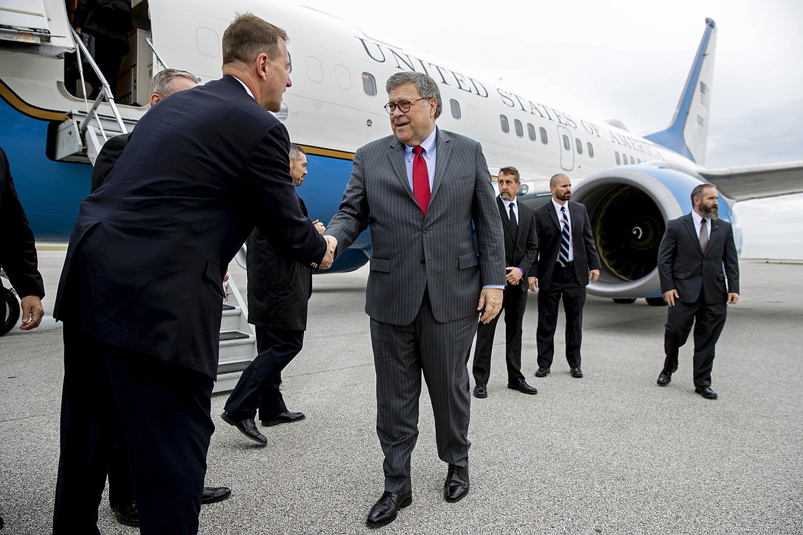 Attorney General William Barr greets members of the Cleveland FBI field office's SWAT team before boarding an aircraft at Burke Lakefront Airport, Thursday, Nov. 21, 2019, in Cleveland. Barr participated in a roundtable discussion with members of local, state and federal law enforcement, and is en route to Montana, where he is scheduled Friday to address missing and murdered indigenous persons. (AP Photo/Patrick Semansky)