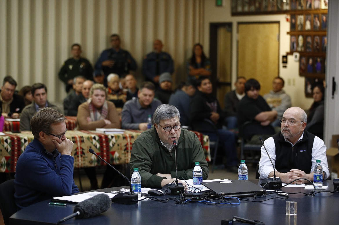 Attorney General William Barr speaks at a Confederated Salish and Kootenai Tribes council meeting, Friday, Nov. 22, 2019, on the Flathead Reservation in Pablo, Mont. Sitting with Barr are Kurt Alme, left, U.S. Attorney for the District of Montana, and Tracy Toulou, director of the Justice Department's Office of Tribal Justice. (AP Photo/Patrick Semansky)