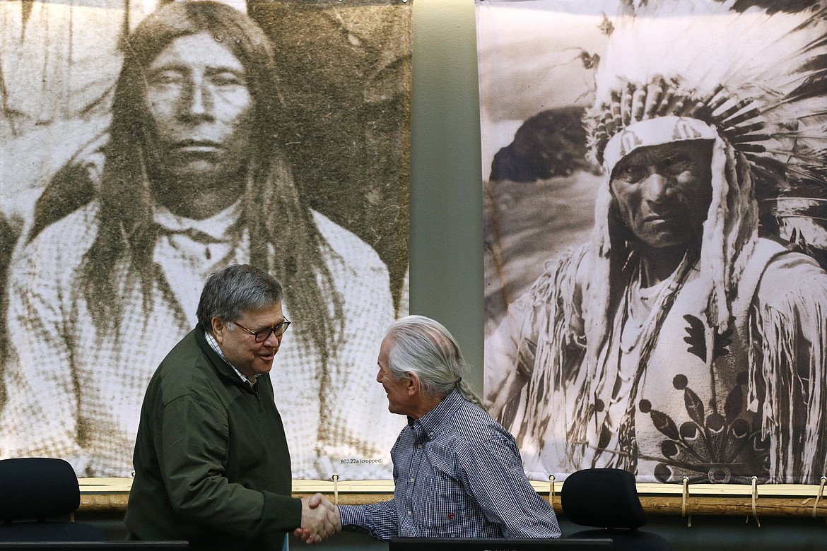Attorney General William Barr greets Leonard Gray, vice chairman of the Confederated Salish and Kootenai Tribes council, before speaking at a council meeting, Friday, Nov. 22, 2019, on the Flathead Reservation in Pablo, Mont. (AP Photo/Patrick Semansky)