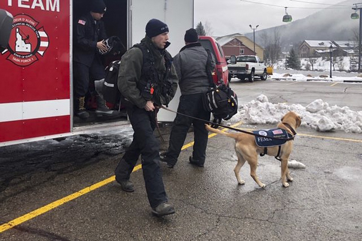 In this Tuesday, Jan. 7, 2020, photo provided by KHQ, the Coeur d'Alene Fire Department K-9 Team responds to Silver Mountain for an avalanche in Kellogg, Idaho. Officials are searching for a person who was skiing at an Idaho resort near where avalanches killed two skiers and injured five others. The Silver Mountain Resort near the town of Kellogg was closed Wednesday to focus resources on the search for the missing skier. (KHQ via AP)