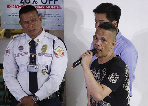 CAPTION CORRECTION CORRECTS FIRST NAME: Former security guard Alchie Paray, right, talks to media shortly after releasing all his hostages at the V-mall in Manila, Philippines, Monday, March 2, 2020. Officials say a recently dismissed security guard has released his hostages and walked out of a Philippine shopping mall, ending a daylong hostage crisis. (AP Photo/Aaron Favila)