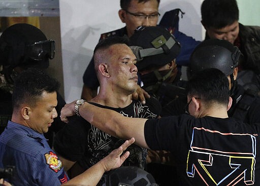 CAPTION CORRECTION CORRECTS FIRST NAME: Alchie Paray, center, is escorted by police shortly after releasing all his hostages at the V-mall in Manila, Philippines on Monday, March 2, 2020. Officials say a recently dismissed security guard has released his hostages and walked out of a Philippine shopping mall, ending a daylong hostage crisis. (AP Photo/Aaron Favila)