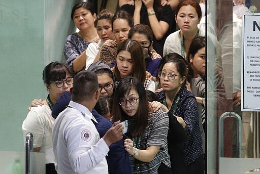 Hostages walk out at the V-Mall in Manila, Philippines on Monday, March 2, 2020. Officials say Paray, a recently dismissed security guard, has released his hostages he took and walked out of the shopping mall, ending a daylong hostage crisis. (AP Photo/Aaron Favila)