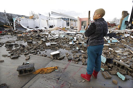 Faith Patton looks over buildings destroyed by storms Tuesday, March 3, 2020, in Nashville, Tenn. Tornadoes ripped across Tennessee early Tuesday, shredding buildings and killing multiple people. Patton lives near the damaged area but her home was intact. (AP Photo/Mark Humphrey)