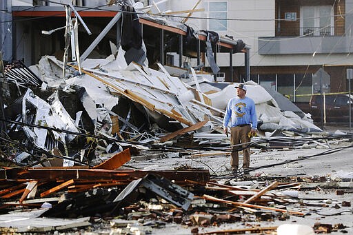 A man looks over buildings destroyed by storms Tuesday, March 3, 2020, in Nashville, Tenn. Tornadoes ripped across Tennessee early Tuesday, shredding buildings and killing multiple people. (AP Photo/Mark Humphrey)