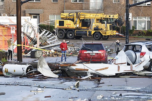 People look over storm damage Tuesday, March 3, 2020, in Nashville, Tenn. Tornadoes ripped across Tennessee early Tuesday, shredding buildings and killing multiple people. (AP Photo/Mark Humphrey)