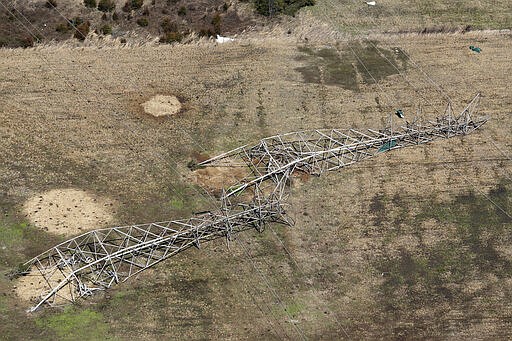 Power line towers lie on the ground in a Tuesday, March 3, 2020 aerial photo, near Lebanon, Tenn. Tornadoes ripped across Tennessee early Tuesday, shredding more than 140 buildings and burying people in piles of rubble and wrecked basements. At least 22 people were killed. (AP Photo/Mark Humphrey)
