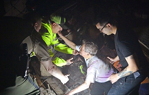 Bill Wallace reaches out to rescue workers who freed him from his home that collapsed on him and his wife Shirley trapping them under rubble after a tornado hit Mt. Juliet, Tenn., on Tuesday, March 3, 2020. ()Larry McCormack/The Tennessean via AP)
