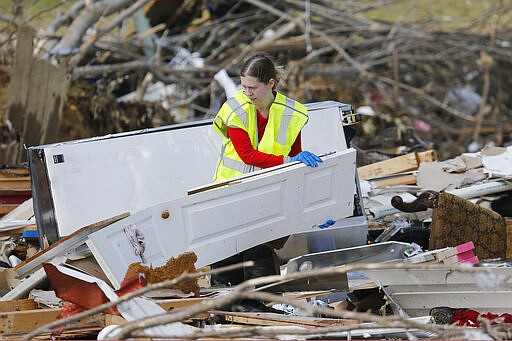 A worker searches for victims among the rubble in an area where several people were killed by storms Tuesday, March 3, 2020, near Cookeville, Tenn. Tornadoes ripped across Tennessee early Tuesday, shredding more than 140 buildings and burying people in piles of rubble and wrecked basements. At least 22 people were killed. (AP Photo/Mark Humphrey)