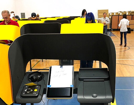 A sign reads &quot;Sorry, Out of Order,&quot; on a voting station as people cast the ballots Tuesday, March 3, 2020, at the Silverlake Independent Jewish Community Center in Los Angeles. Poll workers said that computer network issues slowed both the voter check-in process and made some machines unusable. About one-third of the approximately 40 machines were being used. The resulting line meant voting took about an hour. (AP Photo/Justin Pritchard)