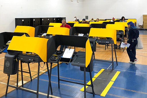 A sign reads &quot;Sorry, Out of Order,&quot; on a voting station as people cast the ballots Tuesday, March 3, 2020, at the Silverlake Independent Jewish Community Center in Los Angeles. Poll workers said that computer network issues slowed both the voter check-in process and made some machines unusable. About one-third of the approximately 40 machines were being used. The resulting line meant voting took about an hour. (AP Photo/Justin Pritchard)