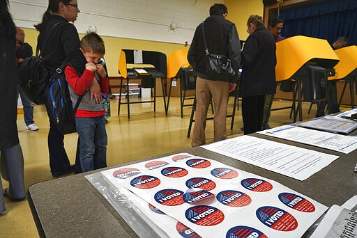 Early voters line up to cast their ballots at the few working voting machines at the Ranchito Avenue Elementary School in the Panorama City section of Los Angeles on Monday, March 2, 2020. Major changes to the way people vote has election advocates on edge as Californians cast ballots in the Democratic presidential contest and other primary races. (AP Photo/Richard Vogel)