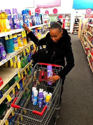 Detroit middle school principal Deborah Charaman stocks up on Lysol disinfectant spray Tuesday, March 3, 2020, at a CVS near downtown Detroit. Charaman says she is concerned about the possibility of the Coronavirus reaching Detroit. The disinfectant is for staff at the school to use to wipe down desks and door knobs. (AP Photo/Corey Williams)