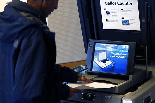 A voter places his ballot in the ballot counter at the downtown library polling site in Minneapolis as part of Minnesota's Super Tuesday presidential nomination primary March 3, 2020. (AP Photo/Jim Mone)