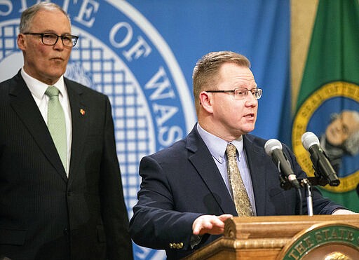 Chris Reykdal, state superintendent of public instruction, speaks about the increase in the number of school closures in interest of public health safety on Monday, March 2, 2020 in Olympia, Wash. Gov. Jay Inslee is behind. (Amanda Snyder/The Seattle Times via AP)