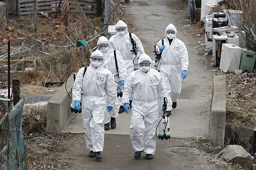 South Korean soldiers wearing protective gears walk to spray disinfectant as a precaution against the new coronavirus in Seoul, South Korea, Tuesday, March 3, 2020. China's coronavirus caseload continued to wane Tuesday even as the epidemic took a firmer hold beyond Asia. (AP Photo/Lee Jin-man)