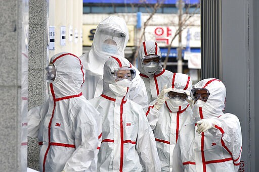 Medical staff members in protective gears arrive for a duty shift at Dongsan Hospital in Daegu, South Korea, Tuesday, March 3, 2020. China's coronavirus caseload continued to wane Tuesday even as the epidemic took a firmer hold beyond Asia, with three countries now exceeding 1,000 cases and the U.S. reporting its sixth death. (Lee Moo-ryul/Newsis via AP)