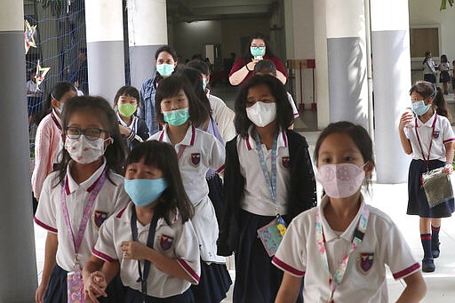 Students wear masks at Jakarta Nanyang School in Serpong on the outskirts of Jakarta, Indonesia, Tuesday, March 3, 2020. Indonesia confirmed its first cases of the coronavirus Monday in two people who contracted the illness from a foreign traveler. (AP Photo/Tatan Syuflana)