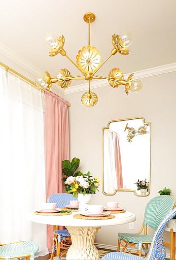 This photo provided by Hudson Valley Lighting Group shows the Alyssa Chandelier by Mitzi. In lighting fixtures, wallpapers, bedding and wall art, floral design is having a big year in 2020. There's also a renewed interest in flower arranging and floral-inspired table settings. (Fred Moser/Kelly Golightly/Mitzi via AP)