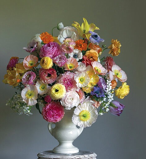 This photo shows a floral display featured in the book "Cultivated: The Elements of Floral Style" by Christin Geall. In lighting fixtures, wallpapers, bedding and wall art, floral design is having a big year in 2020. There's also a renewed interest in flower arranging and floral-inspired table settings. (Christin Geall/Princeton Architectural Press via AP)