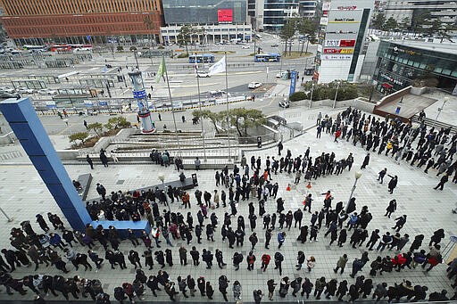 People line up to buy face masks to protect themselves from the new coronavirus in front of Seoul Railway Station in Seoul, South Korea, Tuesday, March 3, 2020. China's coronavirus caseload continued to wane Tuesday even as the epidemic took a firmer hold beyond Asia. (Hong Hae-in/Yonhap via AP)