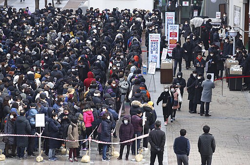 Hundreds of people line up to buy face masks to protect themselves from the coronavirus in front of a department store in Seoul, South Korea, Tuesday, March 3, 2020. China's coronavirus caseload continued to wane Tuesday even as the epidemic took a firmer hold beyond Asia, with three countries now exceeding 1,000 cases and the U.S. reporting its sixth death. (Hong Hae-in/Yonhap via AP)