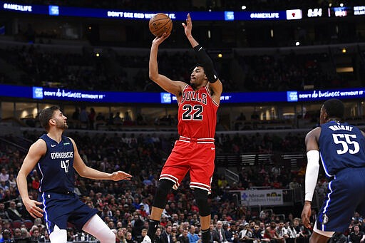 Chicago Bulls' Otto Porter Jr. (22) goes up to shoot against Dallas Mavericks' Maxi Kleber (42), of Germany, and Delon Wright (55) during the second half of an NBA basketball game Monday, March 2, 2020, in Chicago. (AP Photo/Paul Beaty)