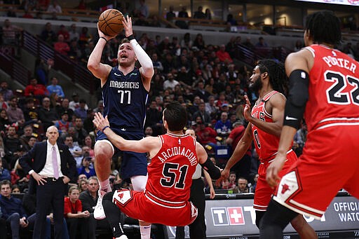 Dallas Mavericks' Luka Doncic (77), of Slovenia, goes up to shoot against Chicago Bulls' Ryan Arcidiacono (51), Coby White (0) and Otto Porter Jr. (22) during the first half of an NBA basketball game Monday, March 2, 2020, in Chicago. (AP Photo/Paul Beaty)