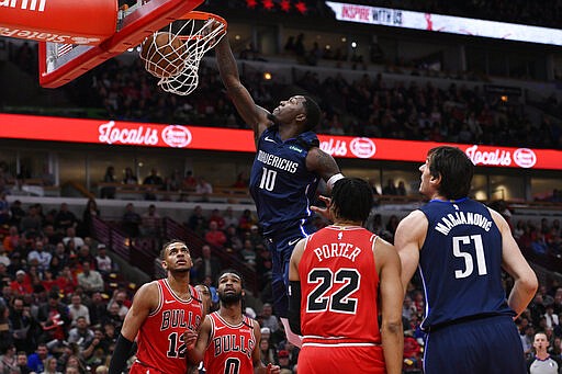 Dallas Mavericks' Dorian Finney-Smith (10) dunks during the first half of an NBA basketball game against the Chicago Bulls, Monday, March 2, 2020, in Chicago. (AP Photo/Paul Beaty)