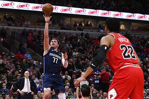 Dallas Mavericks' Luka Doncic (77), of Slovenia, goes up to shoot against Chicago Bulls' Ryan Arcidiacono (51) and Otto Porter Jr. (22) during the first half of an NBA basketball game Monday, March 2, 2020, in Chicago. (AP Photo/Paul Beaty)