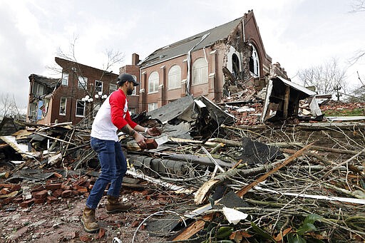 Sumant Joshi helps to clean up rubble at the East End United Methodist Church after it was heavily damaged by storms Tuesday, March 3, 2020, in Nashville, Tenn. Joshi is a resident in the area and volunteered to help clean up. Tornadoes ripped across Tennessee early Tuesday, shredding buildings and killing multiple people.  (AP Photo/Mark Humphrey)