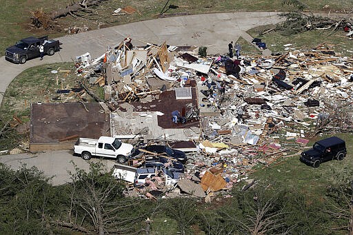 People begin cleaning up Tuesday, March 3, 2020, near Cookeville, Tenn. Deadly tornadoes ripped across Tennessee early Tuesday, shredding more than 140 buildings and burying people in piles of rubble and wrecked basements. (AP Photo/Mark Humphrey)