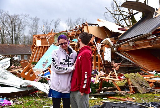 Deanna and Tony Speck, of Cookeville, Tenn., console one another on the front lawn of what's left of Deanna's parent's house off Locust Grove Road on the western edge of Cookeville, Tenn., Tuesday, March 3, 2020. Her parents survived after huddling beneath the staircase as the tornado ripped through the area around 1:30 a.m. (Jack McNeely, Herald-Citizen/The Herald-Citizen via AP)