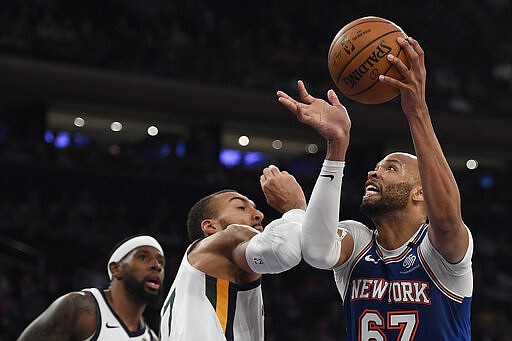 New York Knicks center Taj Gibson (67) drives toward the basket as Utah Jazz forward Royce O'Neale, left, and center Rudy Gobert, center, defend during the first half of an NBA basketball game in New York, Wednesday, March 4, 2020. (AP Photo/Sarah Stier)