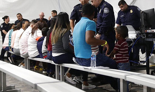 FILE - In this Sept. 17, 2019, file photo, migrants who are applying for asylum in the United States go through a processing area at a new tent courtroom at the Migration Protection Protocols Immigration Hearing Facility, in Laredo, Texas. In the latest twist for a signature Trump administration immigration policy, a federal appeals court said it is halting a policy next week to make asylum-seekers wait in Mexico for court hearings in the United States. But the U.S. 9th Circuit Court of Appeals in San Francisco said Wednesday, March 4, 2020, that it would only block the &quot;Remain in Mexico&quot; policy in Arizona and California, the two border states where its authority extends. (AP Photo/Eric Gay, File)