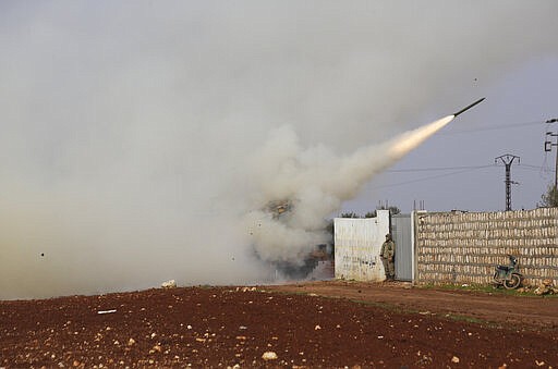 FILE - This Friday, Feb. 14, 2020 file photo, shows Turkish soldiers firing a missile at a Syrian government position in the province of Idlib, Syria. A summit meeting between the Turkish and Russian leaders scheduled for Thursday, March 5, 2020, may be the last chance to work out a deal that avoids a calamity in Syria's northwest. Faced with mounting losses for his troops in Syria and a potential wave of refugees fleeing fighting in northwestern Syria, Turkish President Recep Tayyip Erdogan is eager for a cease-fire and Vladimir Putin is ready to bargain. (AP Photo/Ghaith Alsayed, File)