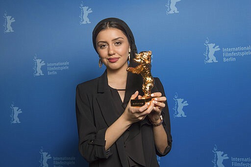 Actress Baran Rasoulof, holds The Golden Bear for Best Film in place of director Mohammad Rasoulof, who did not attend, for the film 'Sheytan vojud nadarad' (There Is No Evil) after the award ceremony at the 70th International Berlinale Film Festival in Berlin, Germany. Saturday, Feb. 29, 2020. (Joerg Carstensen/DPA via AP, Pool)