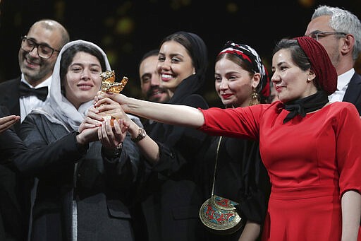 Cast and crew of the film 'Sheytan vojud nadarad' (There Is No Evil), hold The Golden Bear for Best Film in place of director Mohammad Rasoulof, who did not attend, during the award ceremony at the 70th International Berlinale Film Festival in Berlin, Germany. Saturday, Feb. 29, 2020. (AP Photo/Michael Sohn)