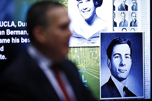 A photo of real estate heir Robert Durst is seen displayed on a screen with a photo of Susan Berman behind Deputy District Attorney John Lewin durning Durst's murder trial at the Airport Branch Courthouse in Los Angeles on Wednesday, March 4, 2020. After a Hollywood film about him, an HBO documentary full of seemingly damning statements, and decades of suspicion, the multimillionaire real estate heir is now on trial for murder. In opening statements Wednesday, prosecutors will argue Durst killed his close friend Susan Berman before New York police could interview her about the 1982 disappearance of Durst's wife. (Etienne Laurent/EPA via AP, Pool)