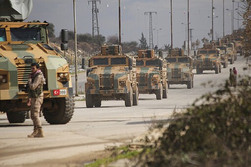 FILE - This Saturday, Feb. 22, 2020 file photo, a Turkish military convoy moves in Idlib province, Syria. A summit meeting between the Turkish and Russian leaders scheduled for Thursday, March 5, 2020, may be the last chance to work out a deal that avoids a calamity in Syria's northwest. Faced with mounting losses for his troops in Syria and a potential wave of refugees fleeing fighting in northwestern Syria, Turkish President Recep Tayyip Erdogan is eager for a cease-fire and Vladimir Putin is ready to bargain. (AP Photo/Ghaith Alsayed, File)