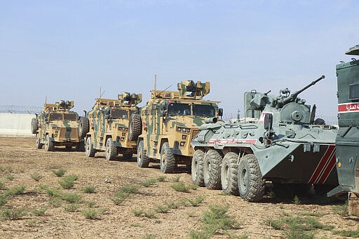 FILE - This Nov. 1, 2019 file photo, Turkish and Russian soldiers patrol near the town of Darbasiyah, Syria. A summit meeting between the Turkish and Russian leaders scheduled for Thursday, March 5, 2020, may be the last chance to work out a deal that avoids a calamity in Syria's northwest. Faced with mounting losses for his troops in Syria and a potential wave of refugees fleeing fighting in northwestern Syria, Turkish President Recep Tayyip Erdogan is eager for a cease-fire and Vladimir Putin is ready to bargain. (AP Photo, File)