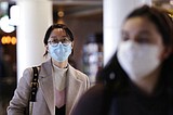 Companies trim outlooks, travel and staff as virus spreads