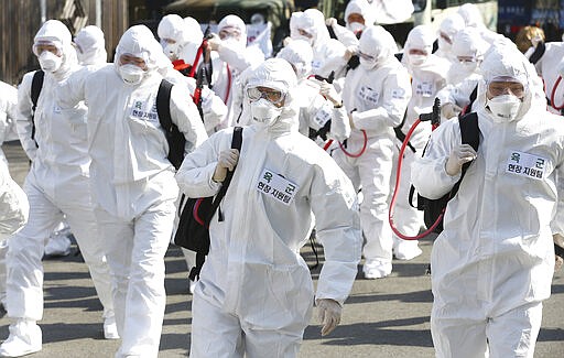 South Korean army soldiers wearing protective gears move to spray disinfectant as a precaution against the new coronavirus in Gyeongan, South Korea, Wednesday, March 4, 2020. (Kim Hyun-tae/Yonhap via AP)