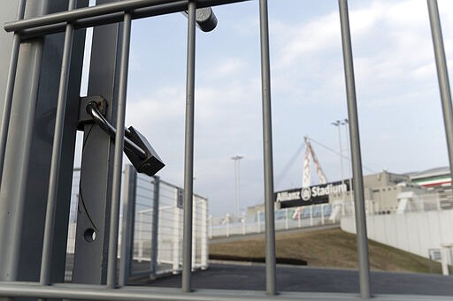 In this picture taken on March 1, 2020 a padlock locks a gate of the Allianz Stadium in Turin, northern Italy. The Italian Cup semifinal between Juventus and AC Milan scheduled for Wednesday, March 4, 2020 in Turin has been postponed indefinitely as part of measures to stop the spread of the virus outbreak in Italy. (Marco Alpozzi/LaPresse via AP)