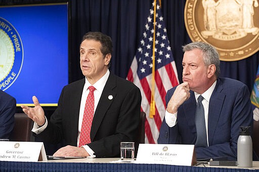 FILE - In this Monday, March 2, 2020, file photo, New York Gov. Andrew Cuomo, left, and Mayor Bill de Blasio discuss the state and city's preparedness for the spread of the coronavirus, in New York. The wife, two children and neighbor of a New York lawyer who is hospitalized in critical condition with COVID-19 have also tested positive for the disease. Gov. Cuomo made the announcement on Wednesday, March 4.  (AP Photo/Mark Lennihan, File)