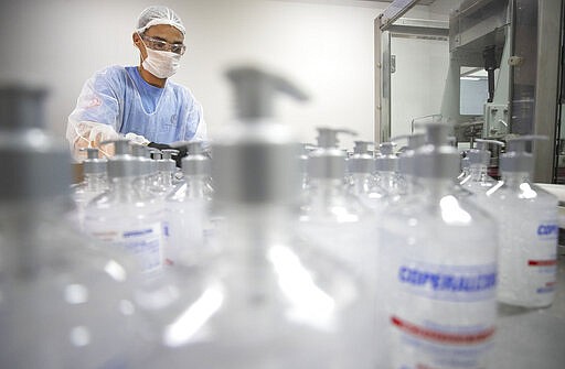 A worker produces hand sanitizer at the Companhia Nacional do &Aacute;lcool (CNA) factory in Piracicaba, Brazil, Tuesday, March 3, 2020. Last week the factory added a second shift of workers to produce more hand sanitizer, and while the CNA was never an exporter, it's considering that by adding a third shift. One week ago, Brazil confirmed Latin America&#146;s first case of the new coronavirus. (AP Photo/Andre Penner)
