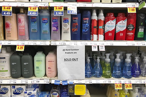 A sign on a shelf at a QFC grocery store in Kirkland, Wash., advises shoppers, Tuesday, March 3, 2020, that all hand sanitizer products are sold out. Fear of the coronavirus has led people to stock up on the germ-killing gel, leaving store shelves empty and online retailers with sky-high prices set by those trying to profit on the rush. The store is located near the Life Care Center of Kirkland, which has been tied to several cases of the COVID-19 coronavirus. (AP Photo/Ted S. Warren)