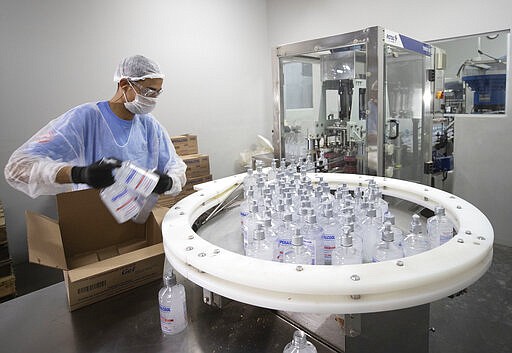 A worker produces hand sanitizer at the Companhia Nacional do &Aacute;lcool (CNA) factory in Piracicaba, Brazil, Tuesday, March 3, 2020. Last week the factory added a second shift of workers to produce more hand sanitizer, and while the CNA was never an exporter, it's considering that by adding a third shift. One week ago, Brazil confirmed Latin America&#146;s first case of the new coronavirus. (AP Photo/Andre Penner)