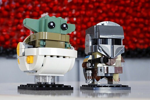 LEGO Baby Yoda, left, and The Mandalorian, part of the BrickHeadz set, are displayed at Toy Fair New York, in the Javits Convention Center, Monday, Feb. 24, 2020. From Baby Yoda to eco-friendly stacking rings, toymakers displayed an array of goods that they hope will be on kids' wish lists for the holiday 2020 season. The four-day Toy Fair comes as the U.S. toy industry has been whipsawed by a number of obstacles.   (AP Photo/Richard Drew)